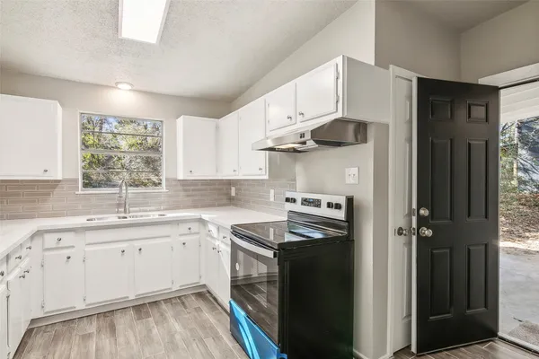 a kitchen with a sink cabinets and window