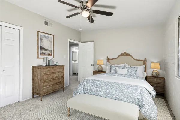 an empty room with windows and fan