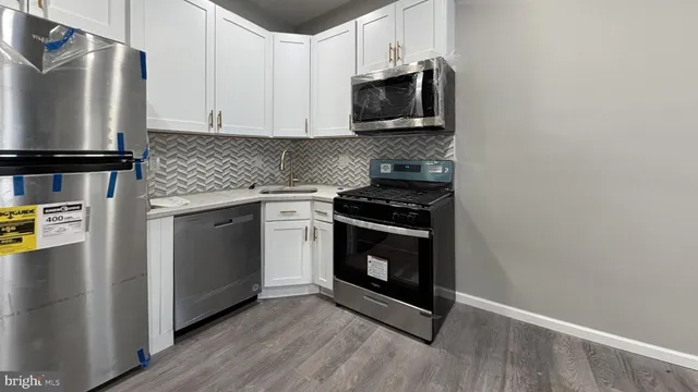 a kitchen with stainless steel appliances granite countertop a stove a microwave and a refrigerator