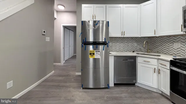 a kitchen with stainless steel appliances granite countertop a refrigerator and a stove