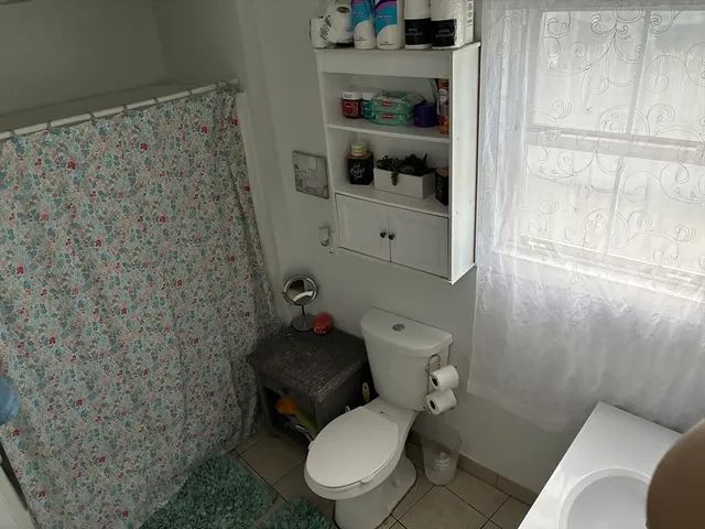 a white toilet sitting next to a bathroom sink and vanity