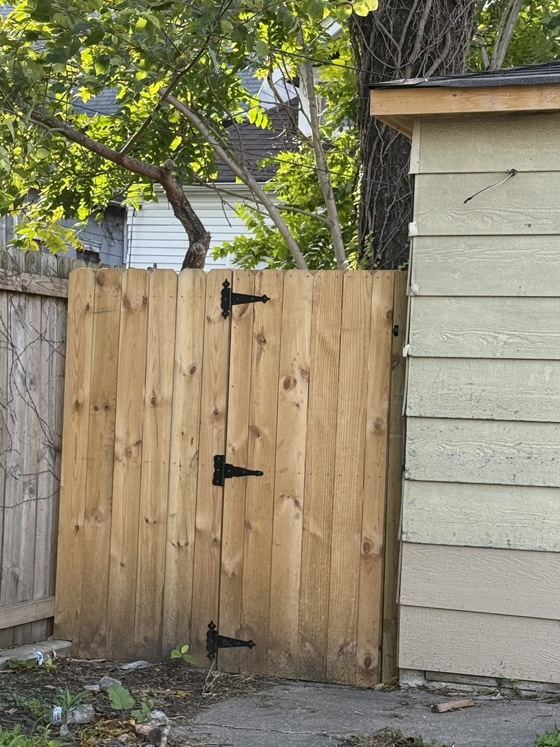 7115 South Peoria Street Chicago, IL 60621 - Photo 18 of 19 a view of a house with a wooden fence