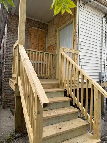 a view of staircase with railing and white walls