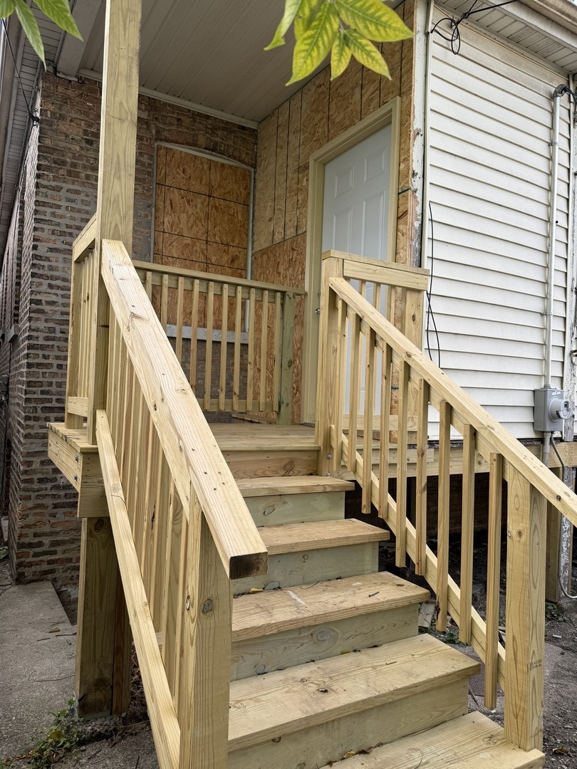 7115 South Peoria Street Chicago, IL 60621 - Photo 4 of 19 a view of staircase with railing and white walls