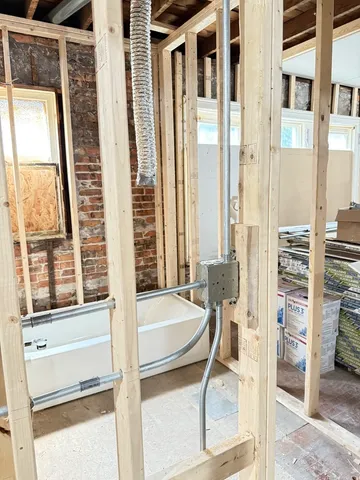 a bathroom with a tub and a view of living room