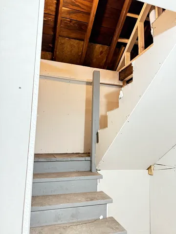 a view of staircase with white walls and a window
