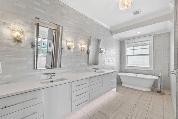 a bathroom with a granite countertop sink mirror and bathtub