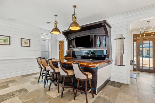 a dining hall with stainless steel appliances granite countertop a stove a oven a dining table and chairs with wooden floor