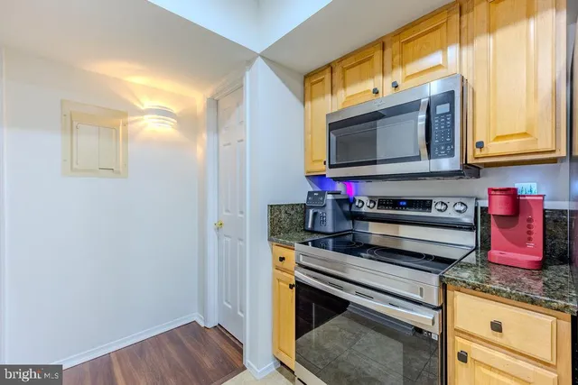 a kitchen with stainless steel appliances granite countertop a stove and a microwave