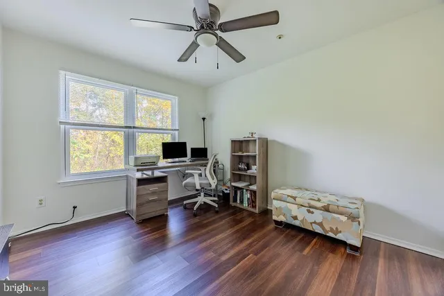 a view of a workspace with furniture and a window