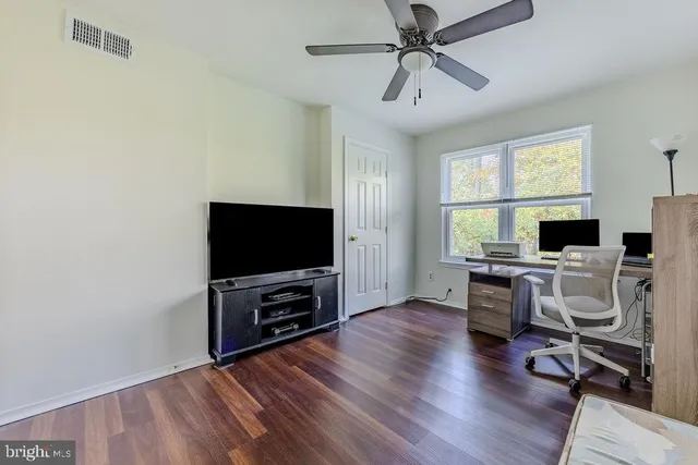 a view of a livingroom with workspace and a window