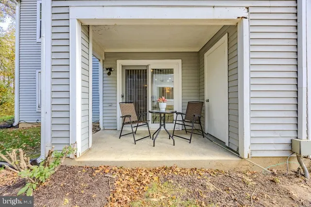 a view of a patio with a table and chairs and potted plants