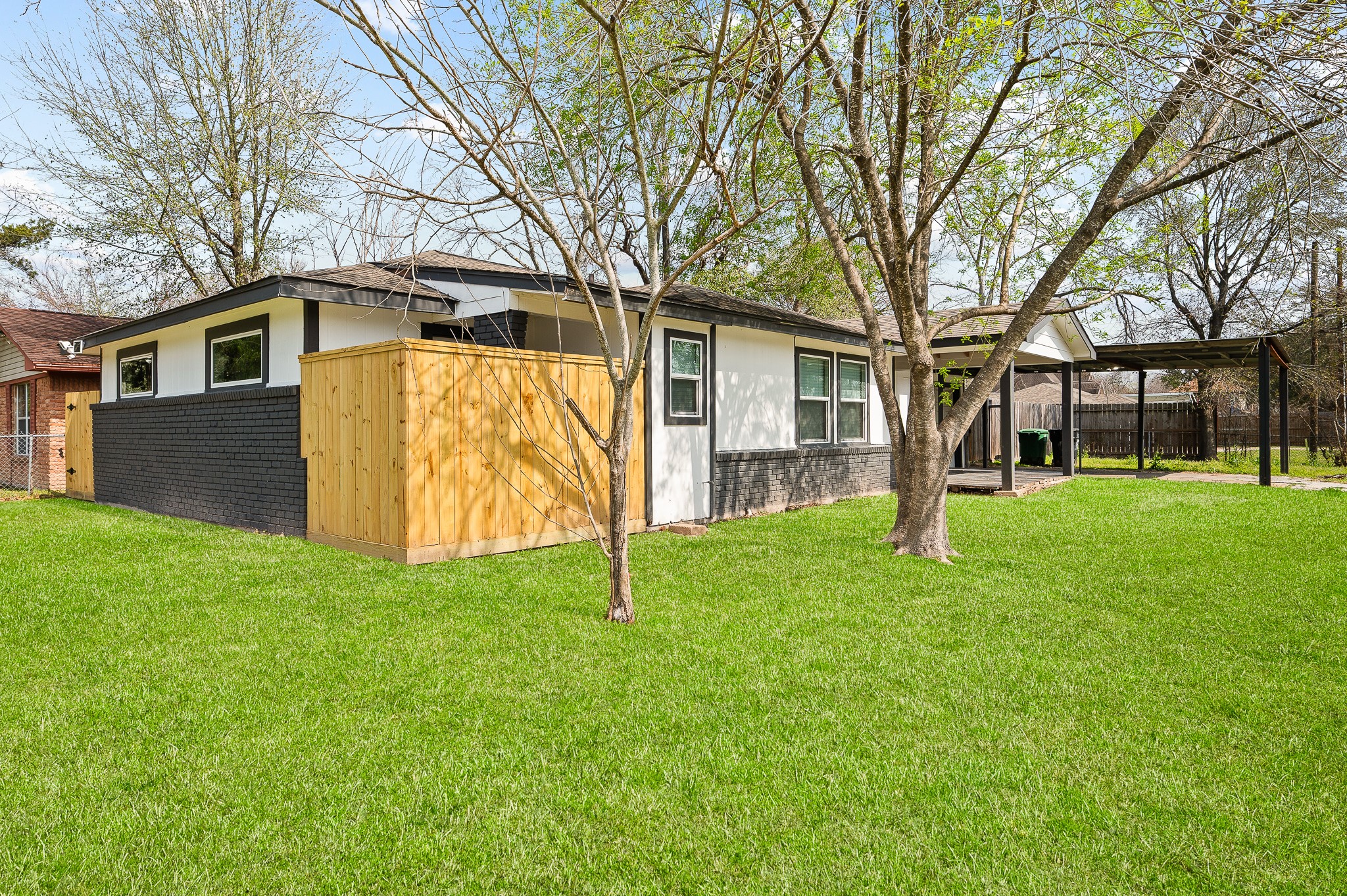 a view of a yard in front of a house with a large tree