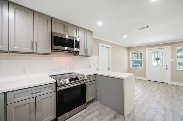 a kitchen with stainless steel appliances granite countertop a stove microwave and sink