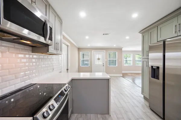 a kitchen with stainless steel appliances granite countertop a sink a stove and a refrigerator