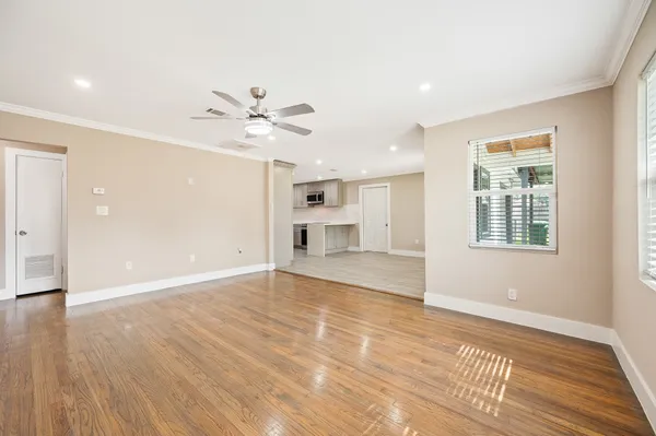 a view of an empty room with a window and wooden floor