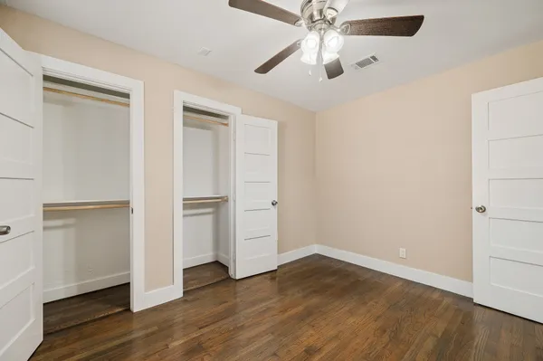 an empty room with wooden floor a ceiling fan and closet