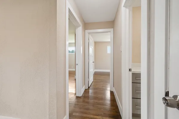 a view of a hallway with wooden floor