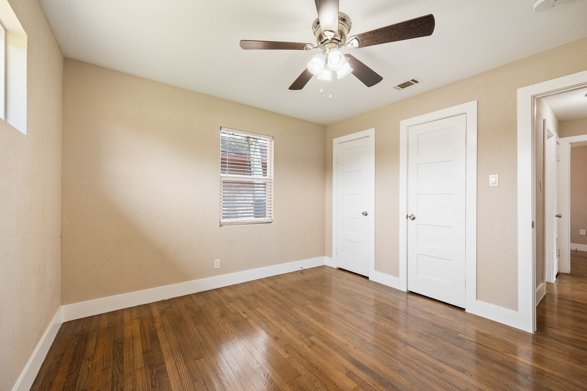 2222 Peppermill Road Houston, TX 77080 - Photo 26 of 38 an empty room with wooden floor ceiling fan and windows