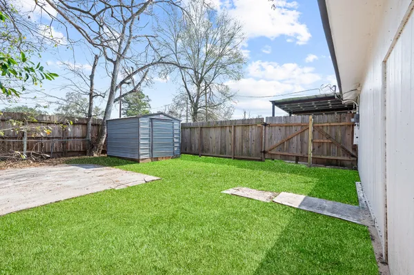 a view of a backyard with wooden fence