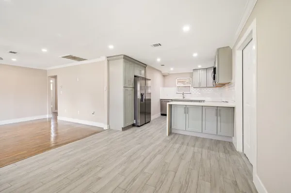 a big room with stainless steel appliances kitchen island wooden floors and view living room