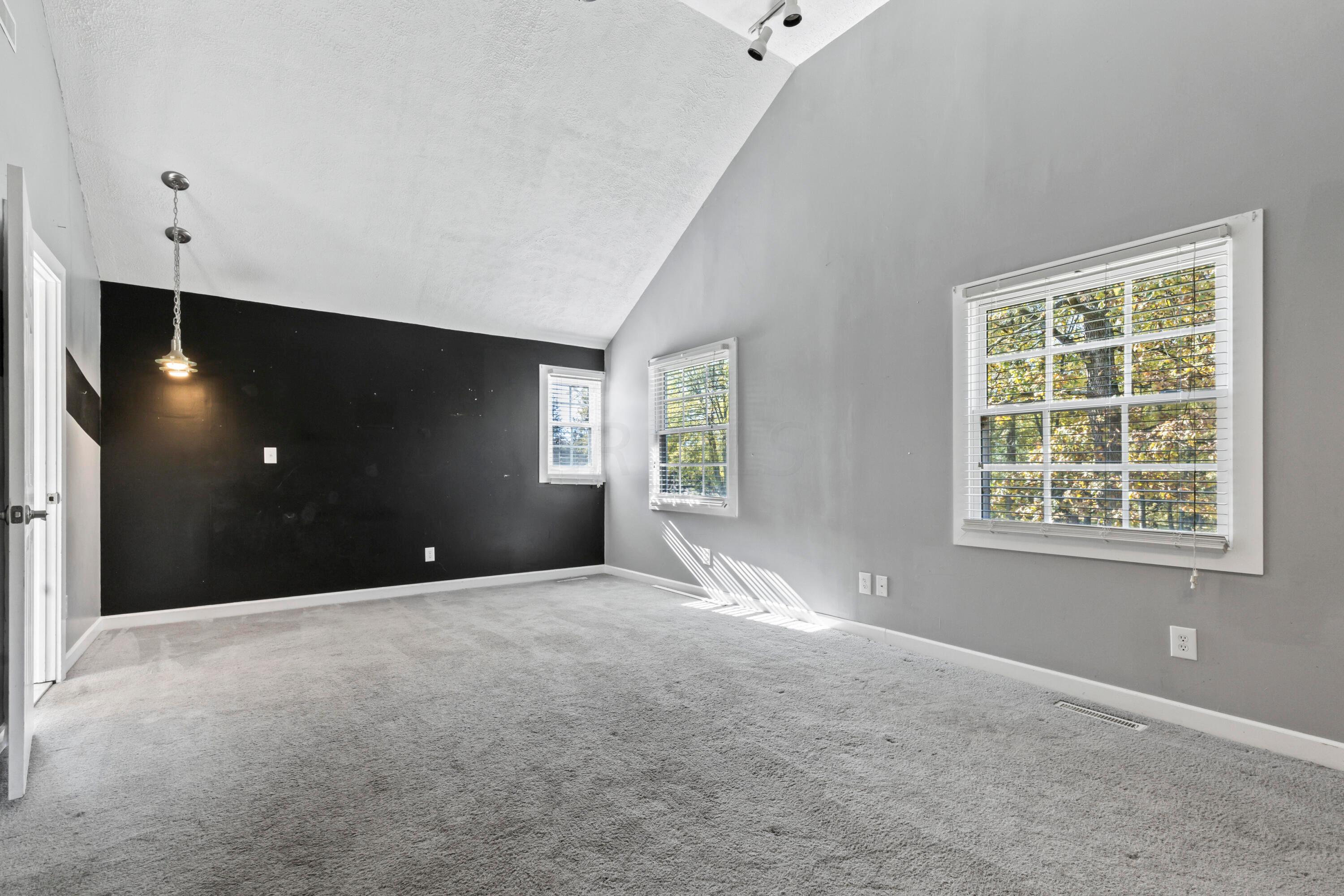 9495 Kilbourne Road Sunbury, OH 43074 - Photo 44 of 84 • Light grey carpet
• Black & grey painted walls
• Cathedral ceiling
• Closet with built-in drawers
& double sliding doors
• Lighted ceiling fan
• Track lighting
• (2) hanging lights