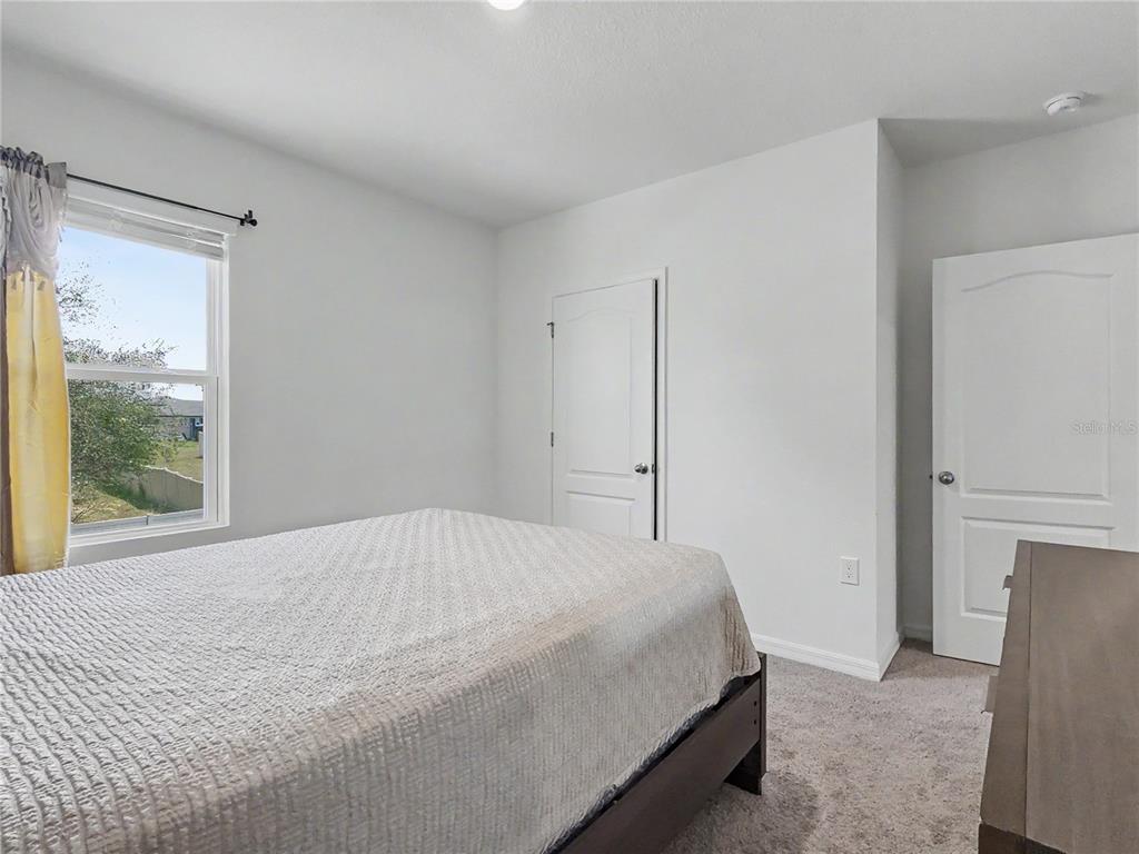 2085 Doe Run Drive Davenport, FL 33837 - Photo 36 of 44 a bedroom with a large bed and a large window