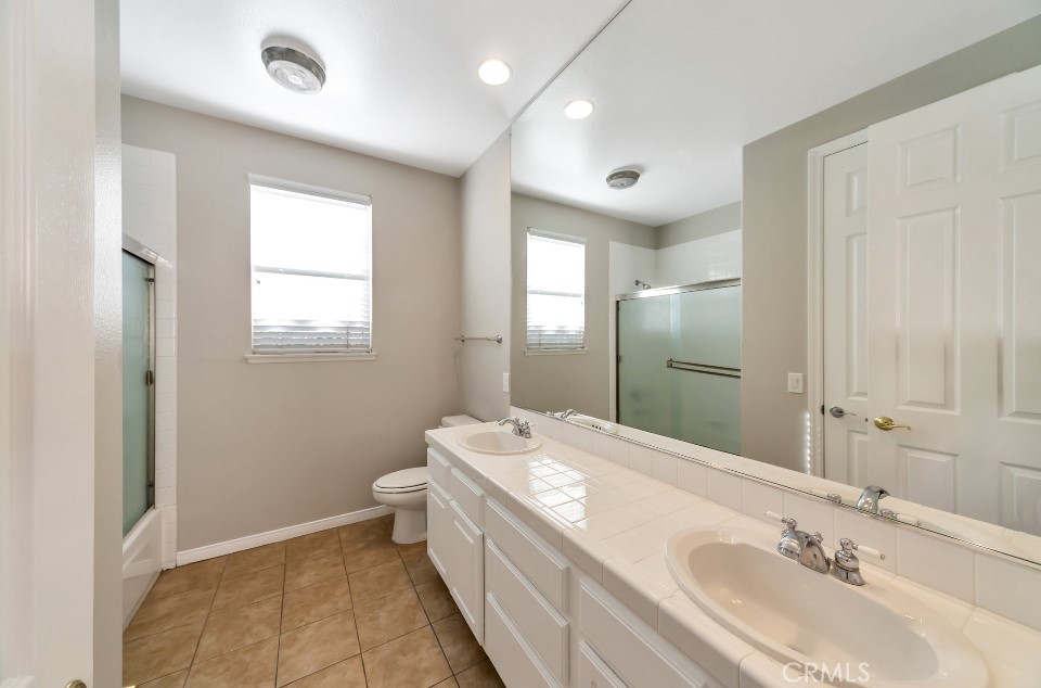 3655 Cll Joaquin Calabasas, CA 91302 - Photo 12 of 15 a bathroom with a granite countertop double vanity sink a mirror and a toilet