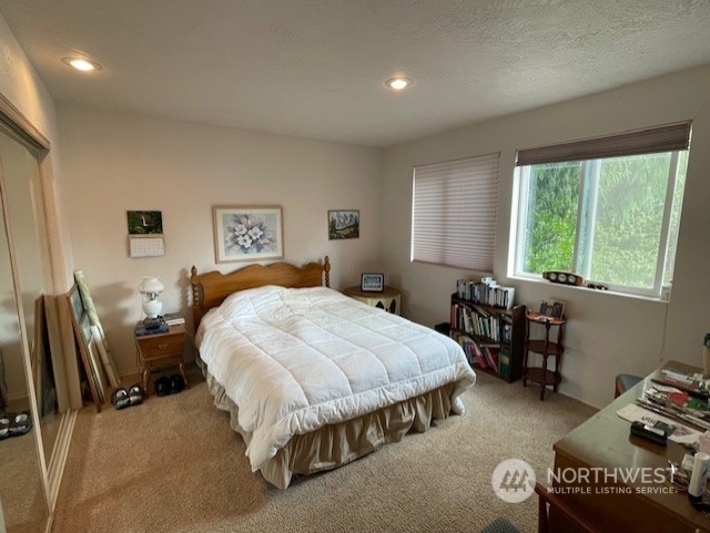 10 Shore Court Grapeview, WA 98546 - Photo 26 of 39 a spacious bedroom with a bed and a table in it