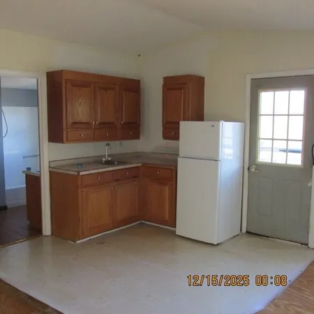 a kitchen with a refrigerator and a stove top oven