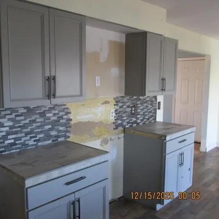 a kitchen with granite countertop a sink and cabinets