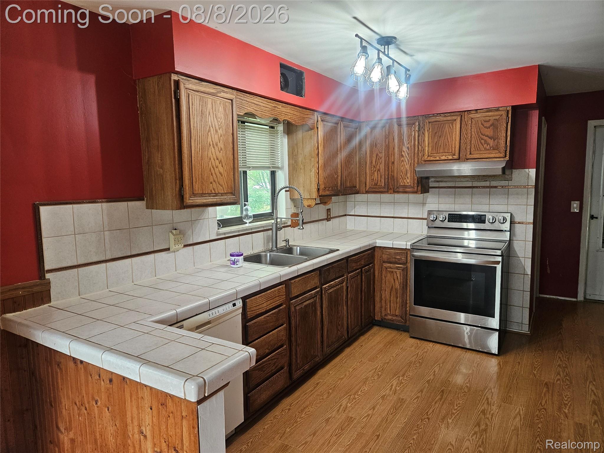 4507 West Wilson Road Clio, MI 48420 - Photo 3 of 14 Kitchen featuring wood-finish flooring and red painted walls