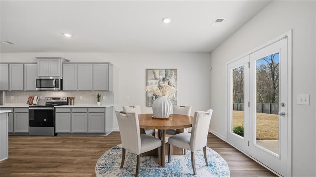 460 Bullock Pass Jefferson, GA 30549 - Photo 14 of 60 a kitchen with granite countertop a dining table chairs cabinets and stainless steel appliances
