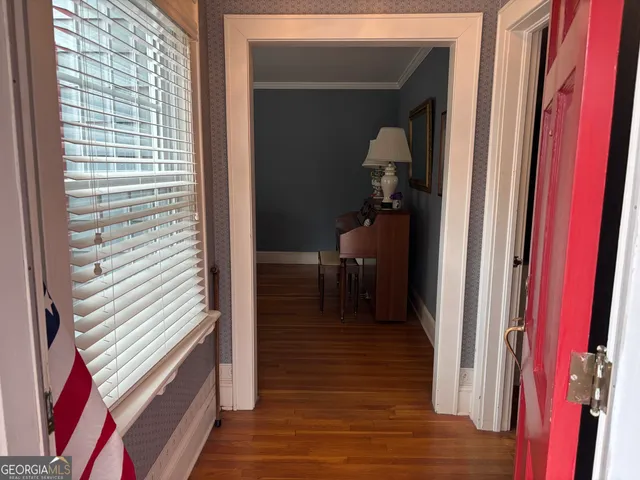 a view of a hallway with wooden floor and staircase
