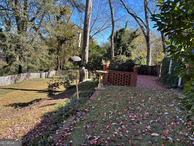 a view of backyard with a table and chairs and wooden fence