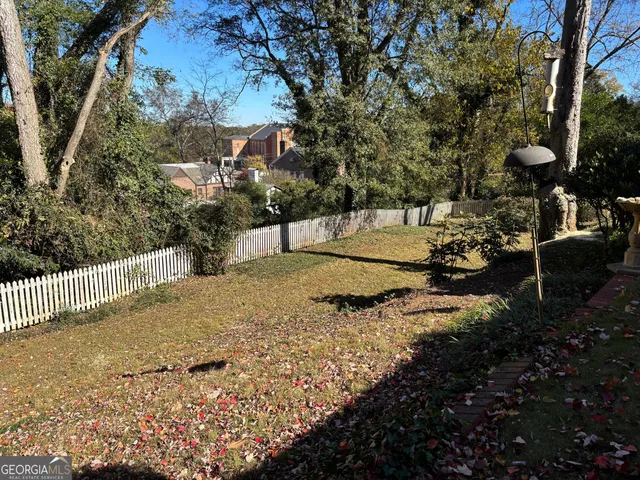 a view of a yard with plants and trees