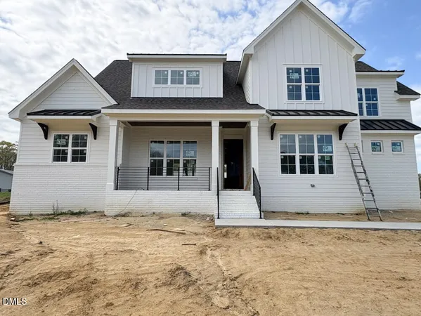 a front view of house with a yard and potted plants
