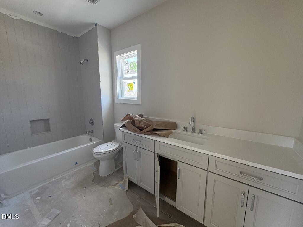 5864 Carriage Gate Drive Raleigh, NC 27603 - Photo 18 of 37 a bathroom with a sink a toilet and bathtub