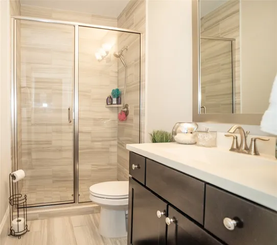 a bathroom with a sink a toilet and shower