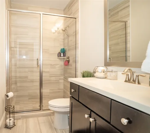 a bathroom with a sink a toilet and shower