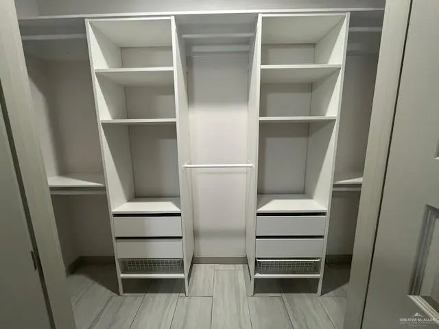 a view of walk in closet with empty racks