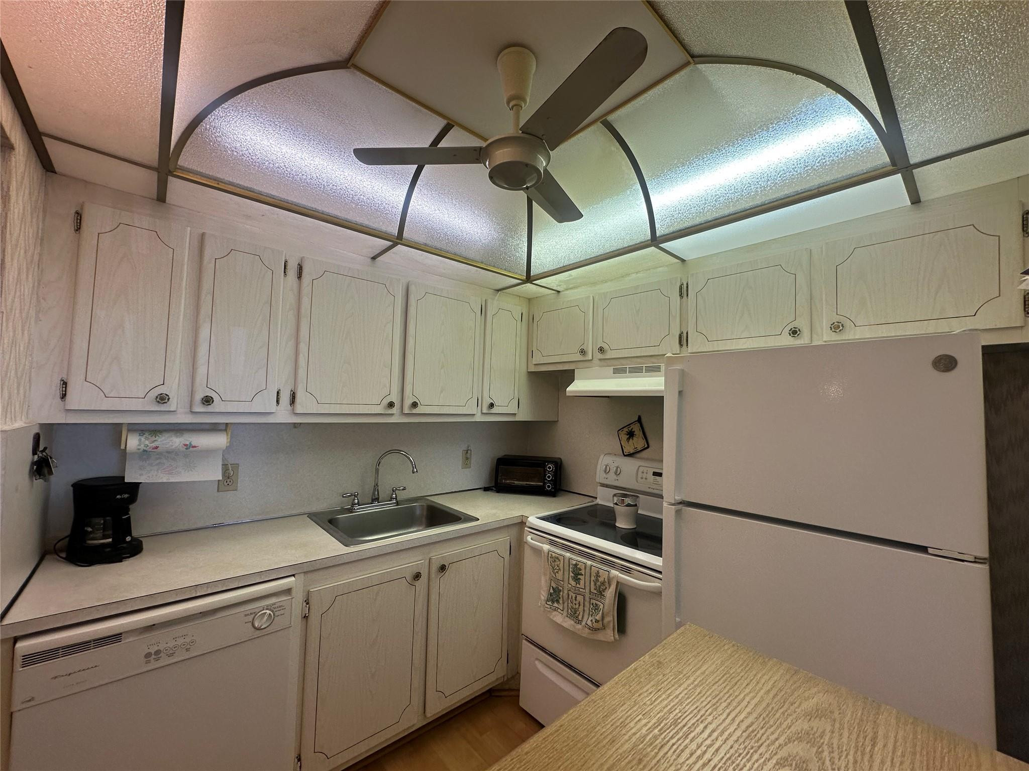 263 Farnham K, Unit 263 Deerfield Beach, FL 33442 - Photo 10 of 48 a kitchen with cabinets appliances and a counter space