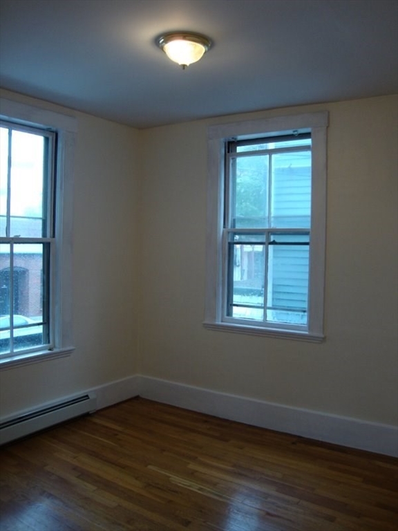 126 Pleasant Street Marblehead, MA 01945 - Photo 12 of 20 an empty room with wooden floor and windows