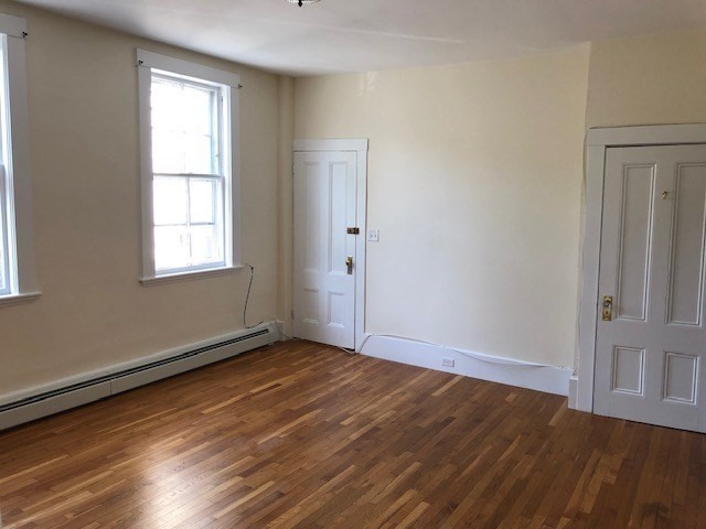 126 Pleasant Street Marblehead, MA 01945 - Photo 5 of 20 an empty room with wooden floor and windows