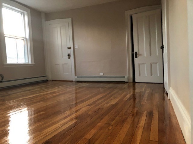 126 Pleasant Street Marblehead, MA 01945 - Photo 10 of 20 an empty room with wooden floor and windows
