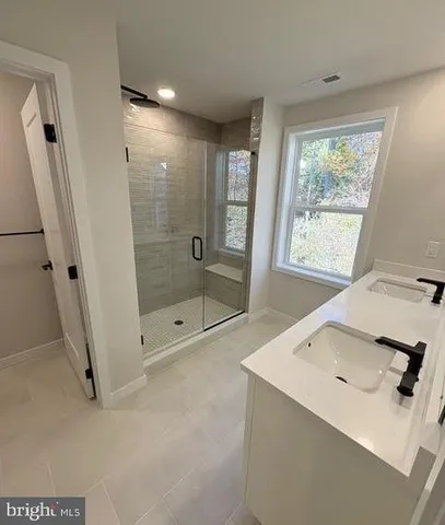 a bathroom with a shower sink and mirror