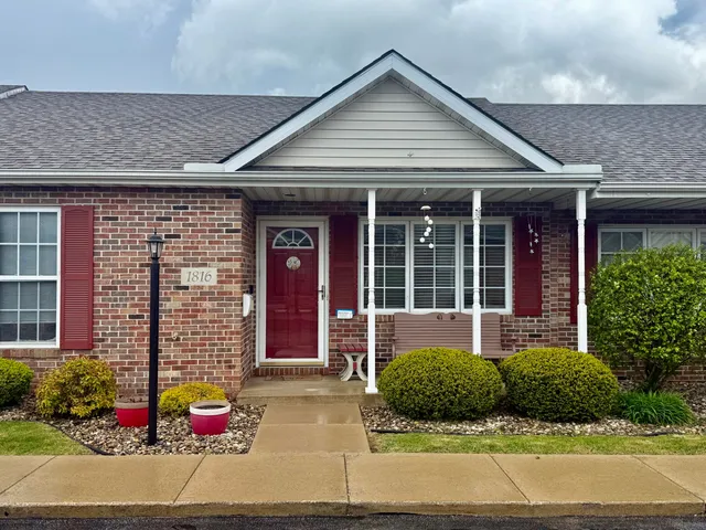 front view of a brick house with a yard