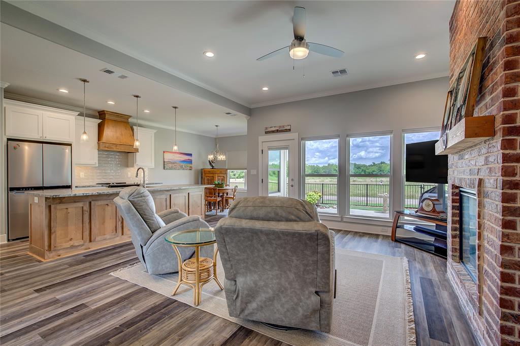 326 Koby Circle Sulphur Springs, TX 75482 - Photo 5 of 38 The great room is expansive, with high ceilings, a wall of windows overlooking your covered back porch, and can lights, plus a brick fireplace surround with an electric fireplace!