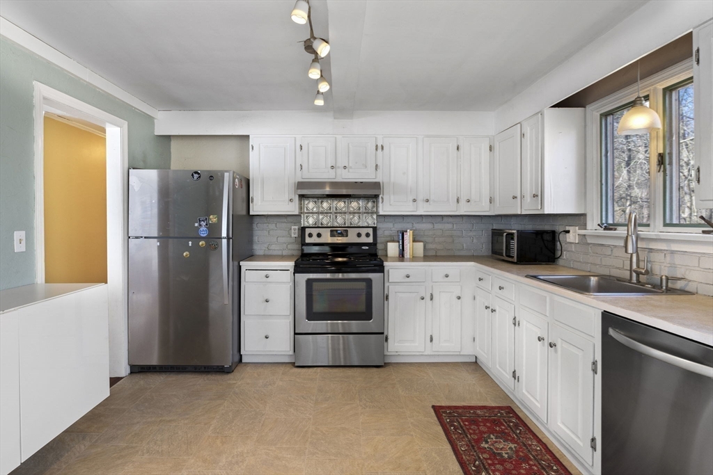 6 True Road Salisbury, MA 01952 - Photo 9 of 40 a kitchen with stainless steel appliances white cabinets and a refrigerator