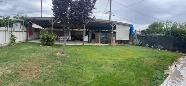 a view of a house with a backyard and sitting area